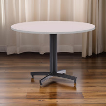Kulatý jídelní stůl s šedou laminátovou deskou.
